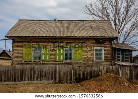 Russian village. Wooden farmhouse behind a wooden picket fence. Hut in the Russian village.