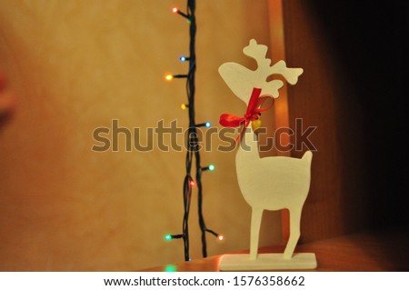Wooden eco christmas toy. White deer with a red ribbon. New Year time concept. Santa's deer, wooden decor for handmade.