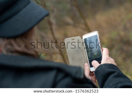 Dressed in black girl takes a photo on the phone