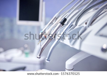 Modern metallic dentist tools and burnishers on a dentist chair in Dentist Clinic. Different dental instruments and tools in a dentists office.  Royalty-Free Stock Photo #1576370125