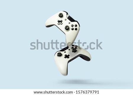 Flying air gamepads from a game console on a blue background. The concept of games, online games, e-sports. Levitation Royalty-Free Stock Photo #1576379791