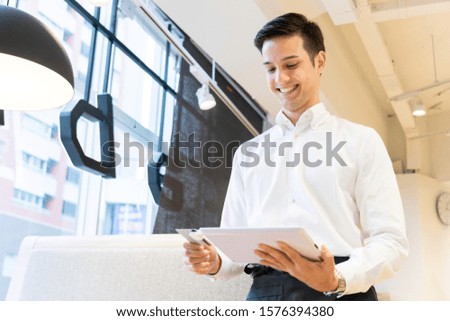 Male clerk paying by credit card on tablet