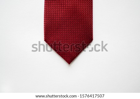 An overhead shot of a red tie on a white surface