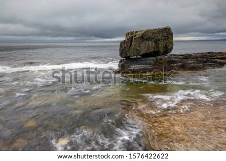 Rock in the sea with dark clouds