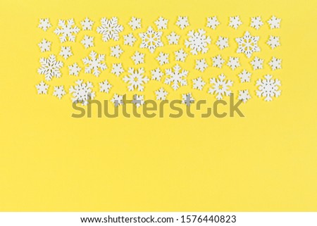 Top view of white snowflakes on colorful background. Winter weather concept with copy space. Merry Christmas concept.