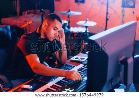 Sound engineer working and mixing music indoors in the studio.
