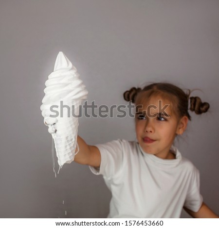 White painted hand holding a white colored ice cream, color melting down the arm, trendy abstract studio shot isolated over white background. Sweets and food art concept, focus on ice cream