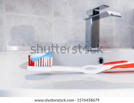Dental health care clinic. Toothbrush with toothpaste applied on it in bathroom.