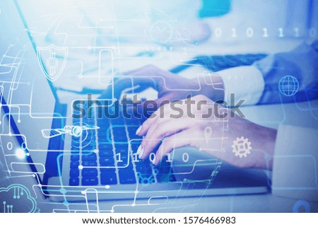 Two businesswomen working with laptop in blurry office with double exposure of blurry business interface. Concept of fintech and technology for business. Toned image