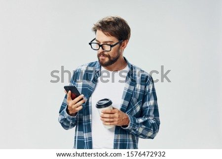 A man in a plaid shirt smartphone holding a charger device