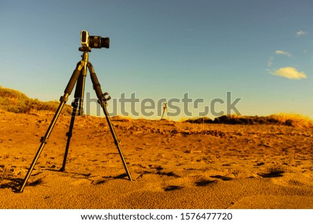 Professional camera taking film video or shooting images pictures on sandy beach dunes