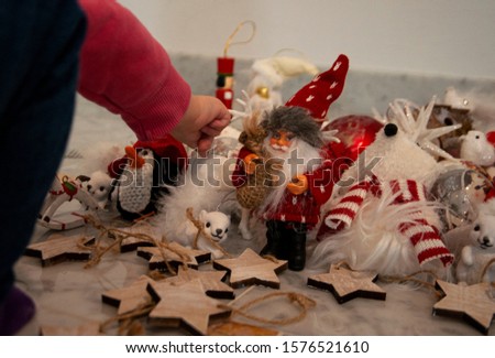 Close-up of little toddler hand playing with Christmas ornaments at home