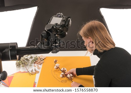 photographer making composition with cotton flower and accessories for photo shooting