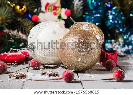 Christmas toys.Santa Claus sock in the snow. Glass ball on wooden background.
