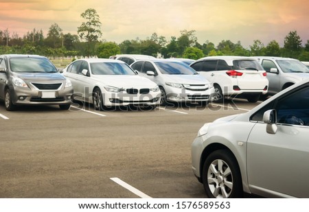 Cars parking in asphalt parking lot with trees, cloudy sky background in a park. Outdoor parking lot with fresh ozone, green environment of transportation and technology concept
 Royalty-Free Stock Photo #1576589563