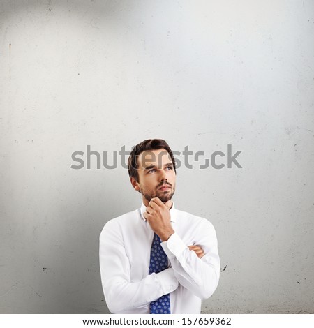 Thoughtful businessman portrait on concrete background