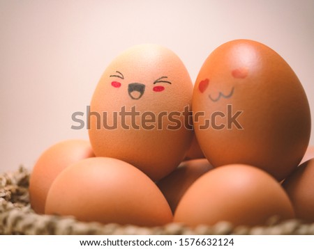 Egg lovers have happy faces of men and women on the pile of eggs in the basket. Organic egg food ingredients, Couples, Easter, Valentine's day concept.
