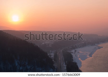 Beautiful winter landscape in the mountains. Sunset over the Yenisei River. Krasnoyarsk. Russia. Siberian winter
