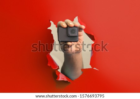 an image of Hand holding small action camera