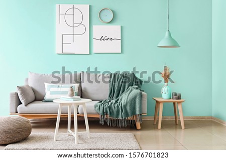 Stylish interior of living room in turquoise color Royalty-Free Stock Photo #1576701823
