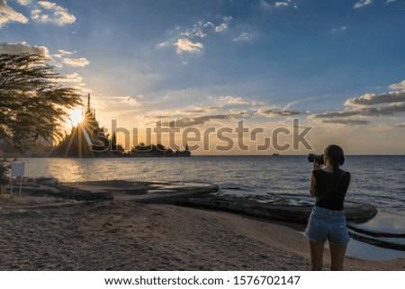  The female tourist taking a photo of Sanctuary of Truth with sun set in Pattaya ,Chonburi , Thailand