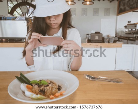 Food photography hobby and casual relaxed lifestyle concept from beautiful asian girl taking photo food and drinks with smartphone at coffee shop for posting on social media.