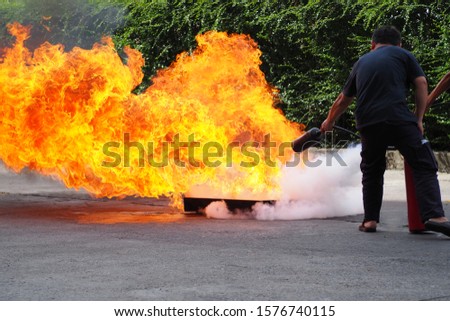 Showing how to use a fire extinguisher on a training fire.