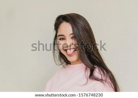 young attractive girl on white background. happy woman smiling. happy teen girl shows tongue