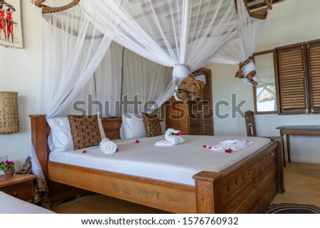 Interior design decor furnishing of luxury show home holiday villa bedroom with four poster bed. Interior design of the tropical villa on the sea on the island of Zanzibar, Tanzania, East Africa