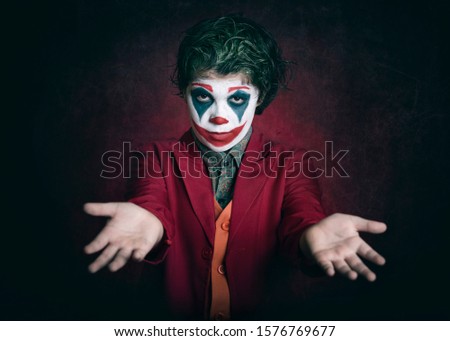 boy dressed as clown on dark background