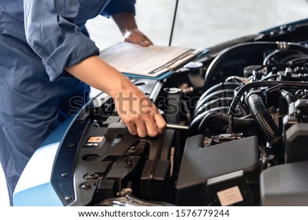 The mechanic is checking the car condition in the car service center. Royalty-Free Stock Photo #1576779244