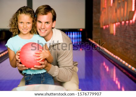 Father and daughter in a bowling alley