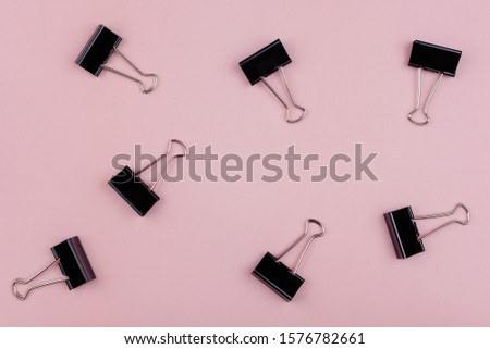 seven stationery clips isolated on pink background