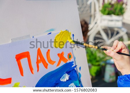 Open air workshop.  Easter Holiday festival in Moscow. A child paintis a picture for Easter. Easter inscription in Russian