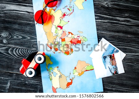 children tourism outfit with map and pictures on dark background flat lay