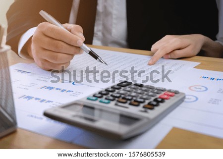 Businessman using calculator to calculate financial data report. Monthly account planning work.