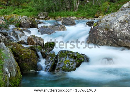 Mountain stream in the middle of mossy rocks at long shutter speed.
