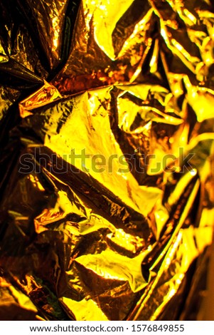 Bright christmas and new year golden background. Shiny yellow gold foil texture.