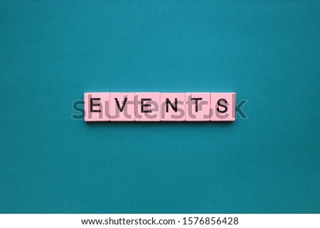Events word wooden cubes on the green background.