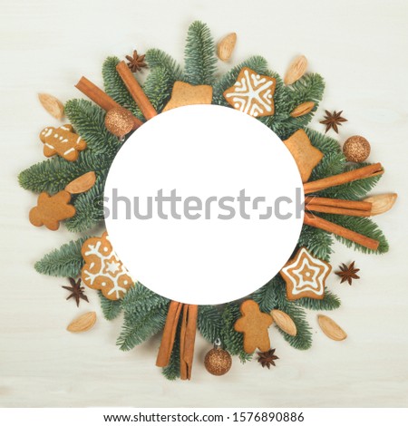 Christmas circle frame of natural fir tree branches and gingerbread cookies with copy space for text