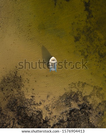 Lone boat floating in the shallow ocean water