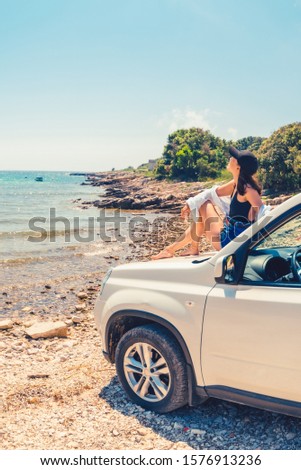 woman laying at car hood with view of sea summer beach