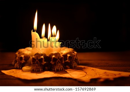 Evil candles on wooden background in the darkness