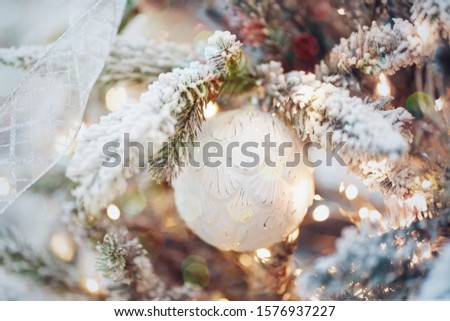Happy New Year and Merry Christmas. New Year mood, snow-covered branch of spruce with balls and lights.