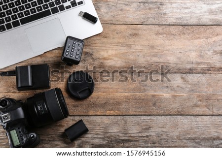 Flat lay composition with equipment for professional photographer on wooden table. Space for text