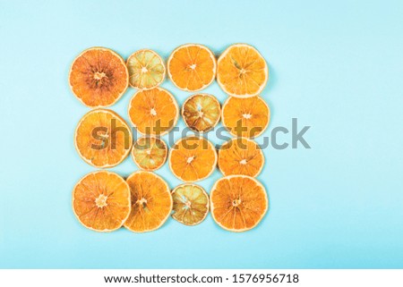 Bright colored dried oranges pattern on a blue background. The concept of homemade eco friendly Christmas decorations. Top viiew, flat lay, background.