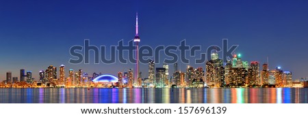 Toronto cityscape panorama at dusk over lake with colorful light.