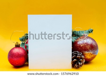 Christmas composition on yellow background. Branches of spruce, cones and balls. Copy space.