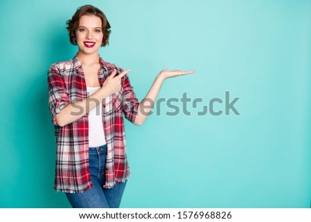 Portrait positive cheerful girl point index finger hold hand indicate ads promo recommend choose decide choice decision advise advice wear good look outfit isolated pastel color background