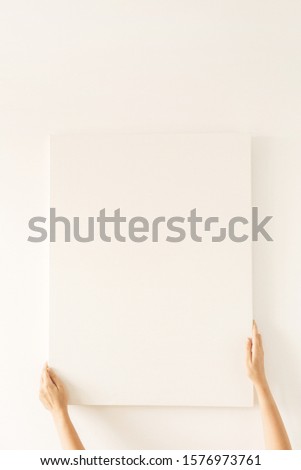 Female hands hold blank canvas with empty mockup copy space. Minimal art concept.